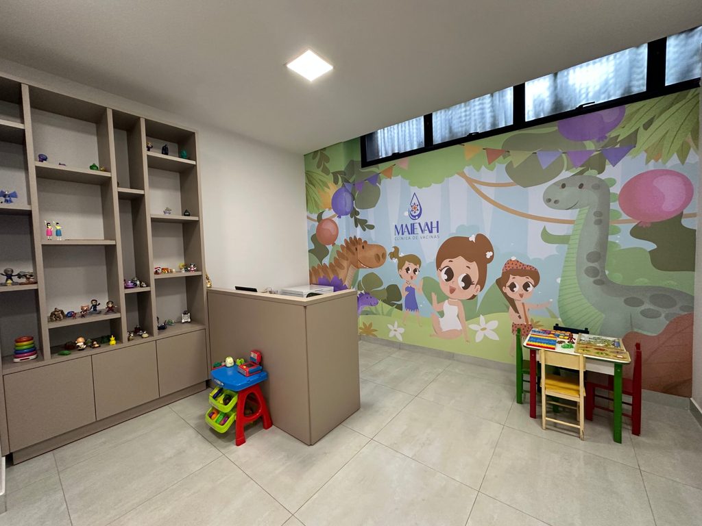 Sala de espera com brinquedos e painel de dinossauros